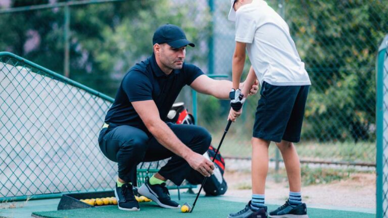 Golf Lessons. Golf instructor giving game lesson to a young boy